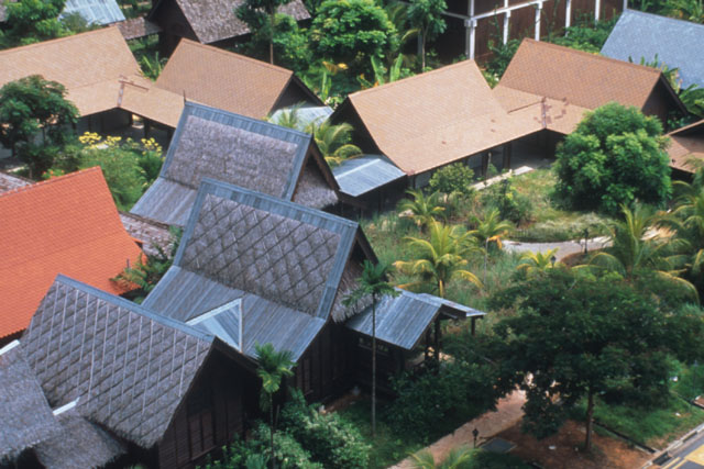 Elevated view showing pitched roofs supported by beams placed in lush garden setting