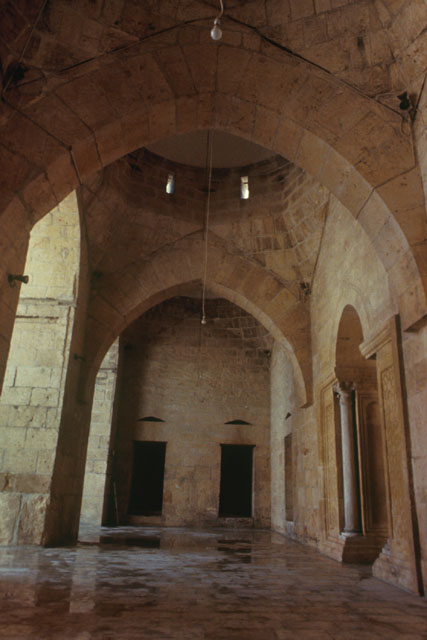 Interior view along arcade showing stone vault system