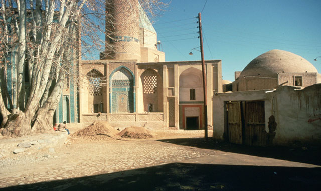 Exterior view from south, showing mosque portal (center), tomb dome (behind minaret) and khanqah portal (behind tree, left)