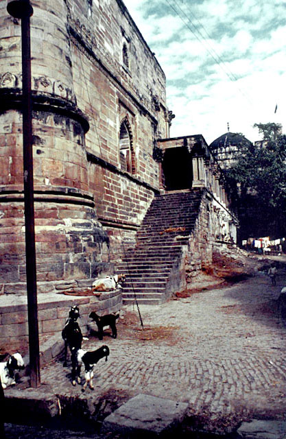 View of courtyard wall from street, showing high steps leading up to the veranda flanking the side entrance