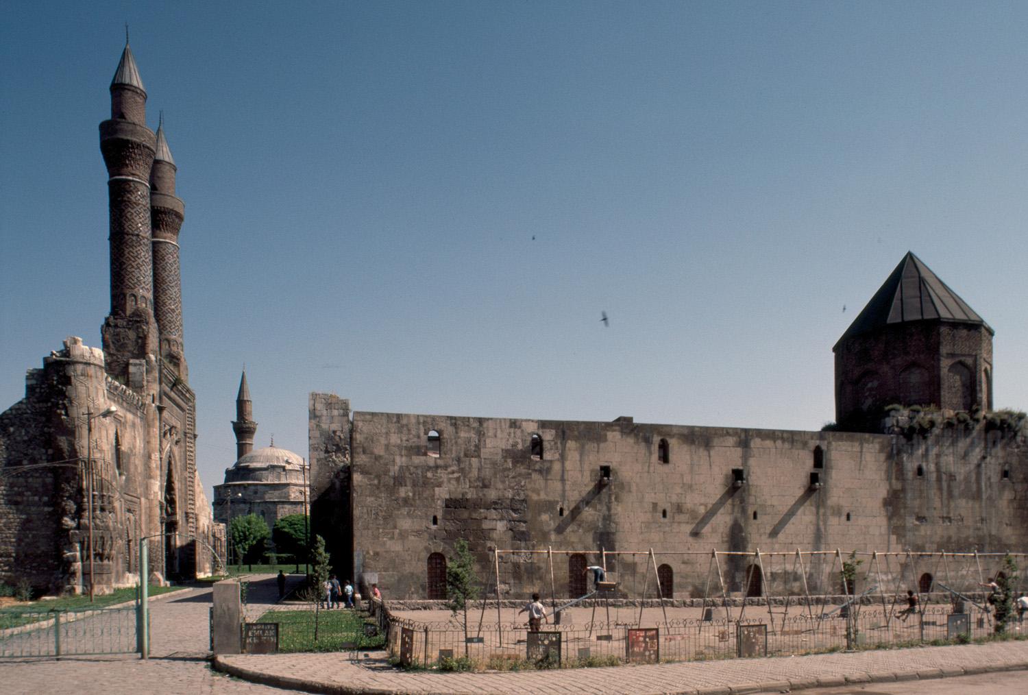 View of Çifte Minaret Madrasa (left) and Izzeddin Keykavus Hospital (right), with Kale Mosque in the background, looking north