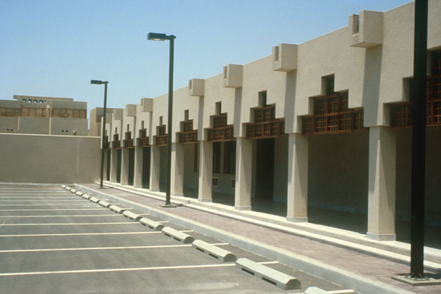Exterior view showing covered path with columned arches with inset wooden screens