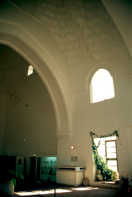 Nilüfer Hatun Imareti - Interior view looking towards the central hall from the eyvan, showing the stalactite vault of the first dome and the great arch that separates the two rooms
