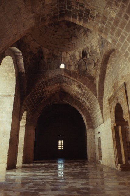 View along arcade showing carved stone muqarnas