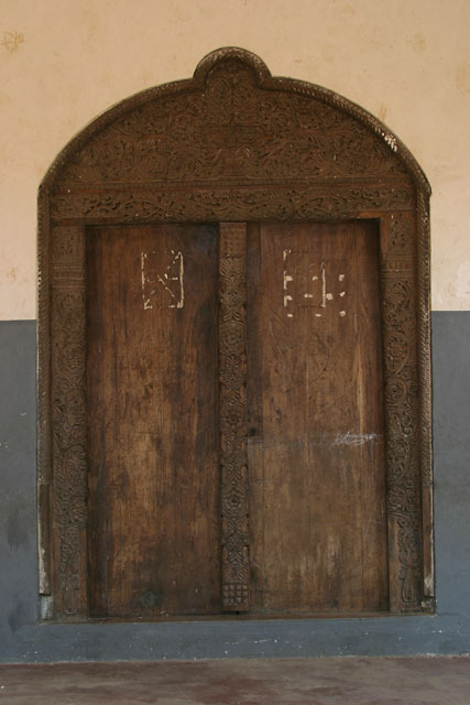 Exterior view of Swahili door with arched lintel and frankincense tree decorative carvings