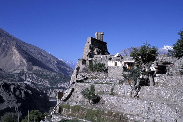General view from east, showing fort on cliff overlooking the Hunza valley (left), and terraced hillside with steps leading up to the village plateau