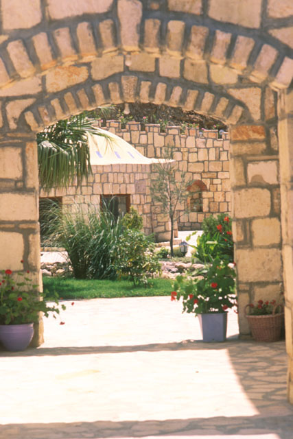 Exterior view through stone arch to central garden