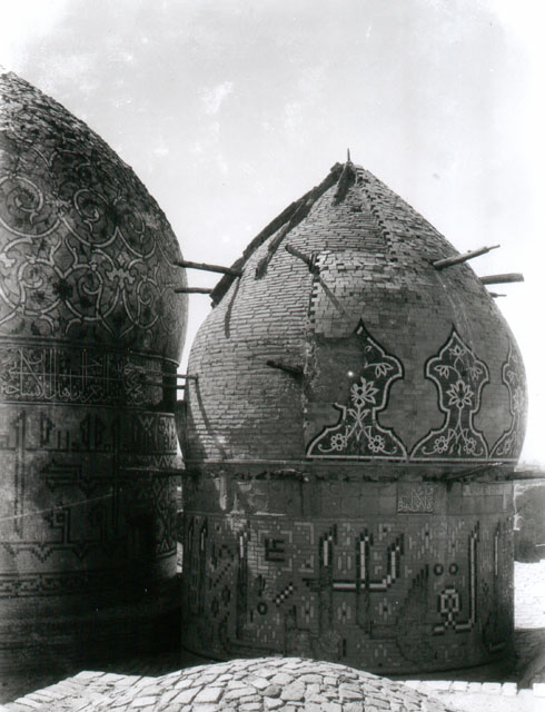 Darb-i Imam - Exterior view of small (northern) dome from east, showing remnants of tile decoration and wooden scaffolding.