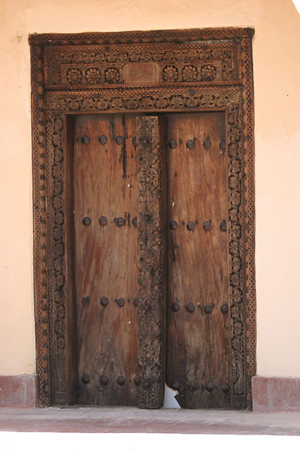 Exterior view of Swahili door in early classical design with metal studded detail and rosette carvings on center-post