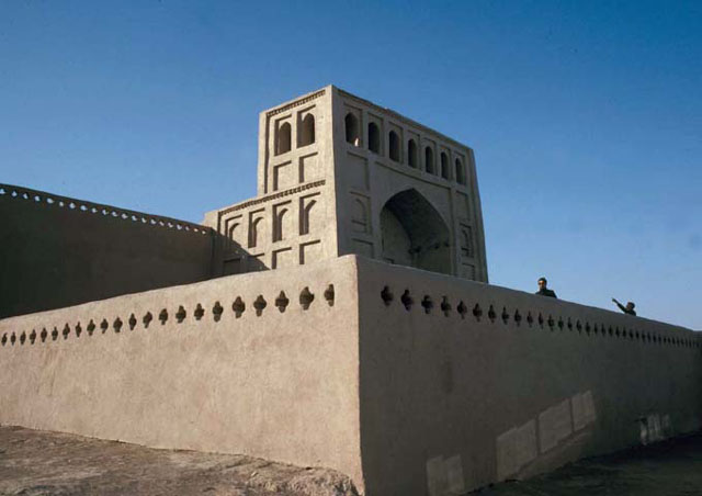 Exterior view from southeast, showing terrace parapet with mosque portal seen behind