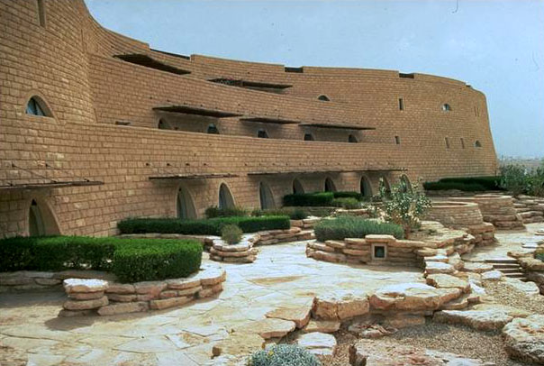 Exterior façade of split-faced limestone walls with landscaping in foreground
