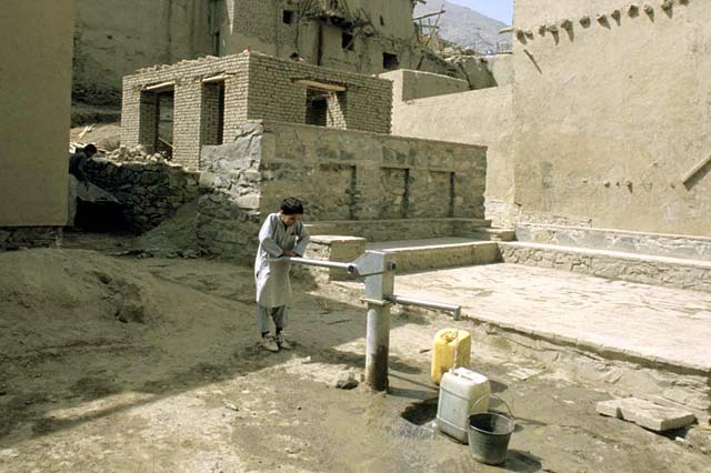 View of paved plaza, with community handpump, after rehabilitation