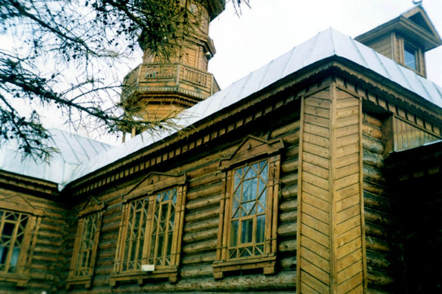Exterior view, showing intricate wood work in façade, windows and minaret