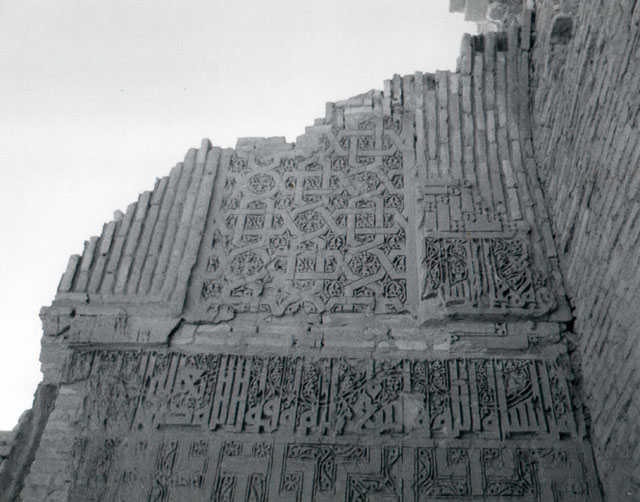 Detail of portal, showing carved stucco inscription and geometric motifs on the left flank