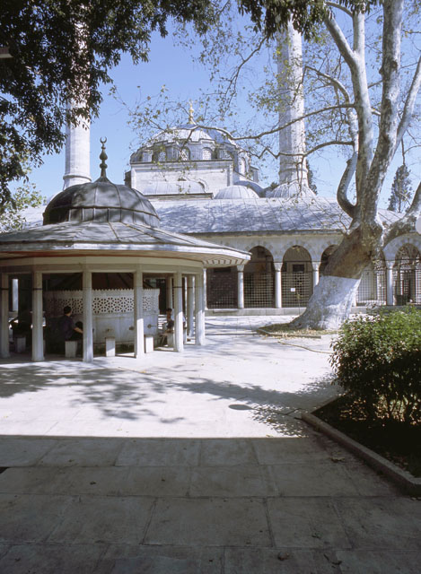 View of mosque courtyard looking north at prayer hall portico and rebuilt ablution fountain