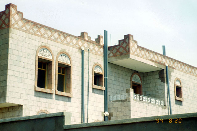 Alguraf Housing - Exterior view showing decorative pieced stucco above windows