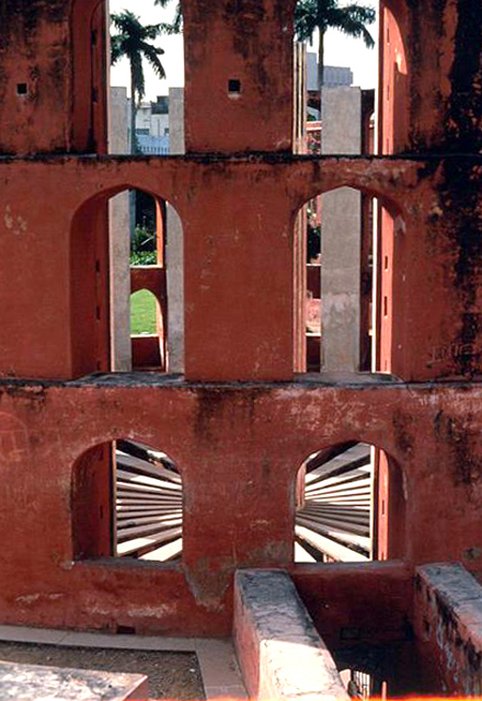 View through the curved wall of the Ram Yantra. The curb of the staircase for entering the instrument can be seen on the bottom right. The radial pattern of the segments of red sandstone is visible through the arched openings of the exterior wall of the instrument