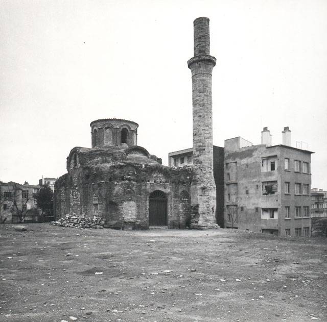 Exterior view showing mosque in its evolving urban context in the 1950s prior to any restoration, with a new door placed at the entrance