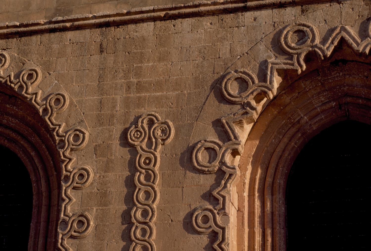 Courtyard detail; archway carved with looped string motif and chain molding in between