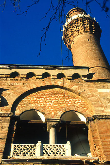 Exterior detail showing double arch at the end of gallery with marble Byzantine capital, and minaret above