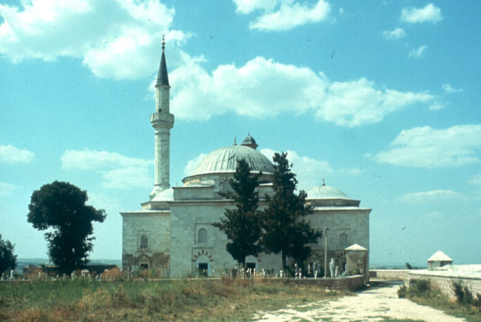 Exterior view of the mosque from south, showing qibla wall and cemetery behind  the precinct walls