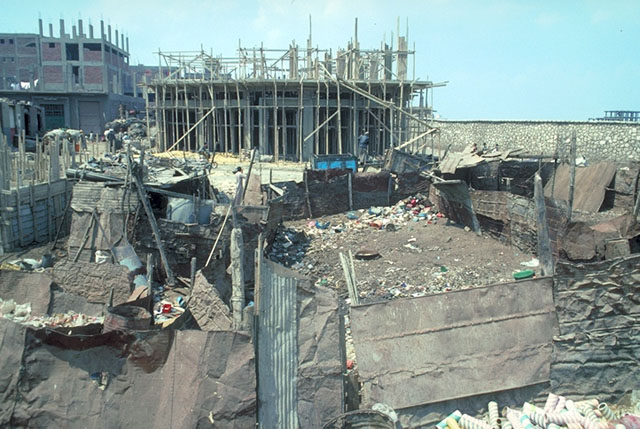 Construction of a new housing block with informal tin shack shelters in foreground