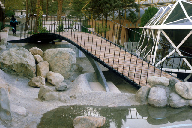 Exterior detail showing foot bridge over water and rock garden