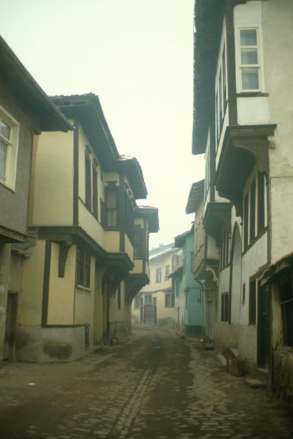 Exterior view along narrow street showing wood and stucco façades