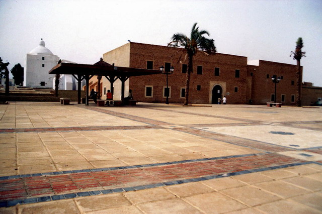 Esplanade paved with red brick, marble and yellow stone paving, with library and mausoleum in the background