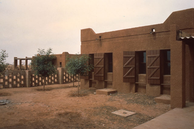 Exterior view showing effect of wood shutters against earthy façade
