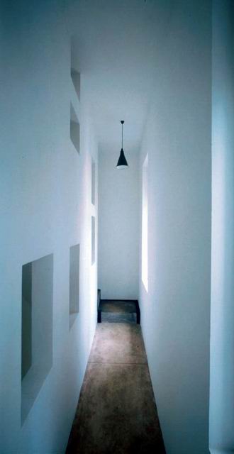 Interior view showing window flooding light through hall and cutouts into living area