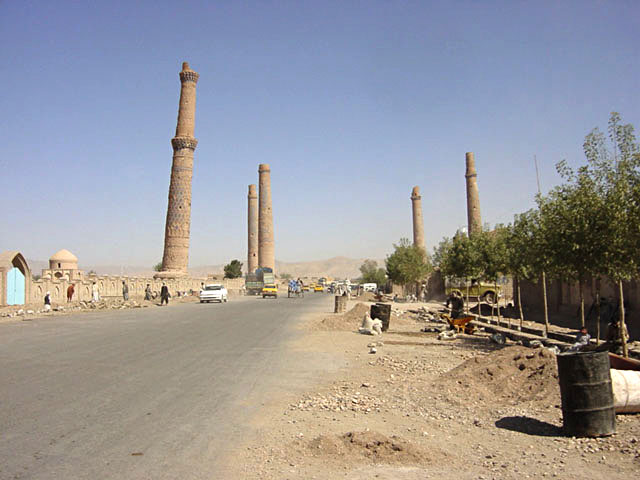 View of complex from southeast, bisected by road, showing minarets remaining from Madrasa of Gawhar Shad (first left) and Madrasa of Husain Baiqara (four in the background). The Mausoleum of Mir Ali Shir Navai appears in the left middle ground