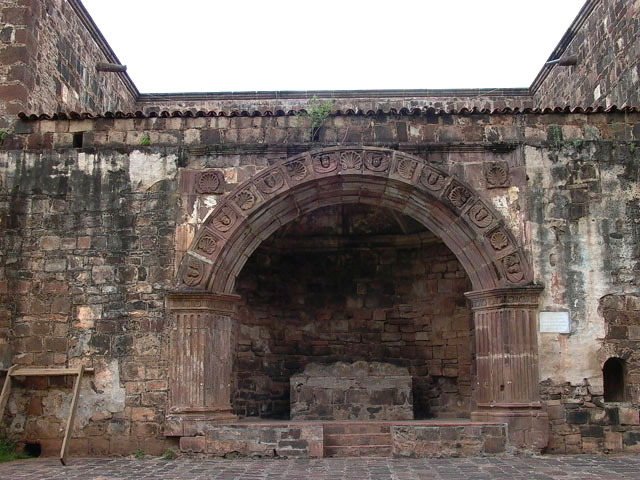 Exterior view of a large arched niche in the stone wall