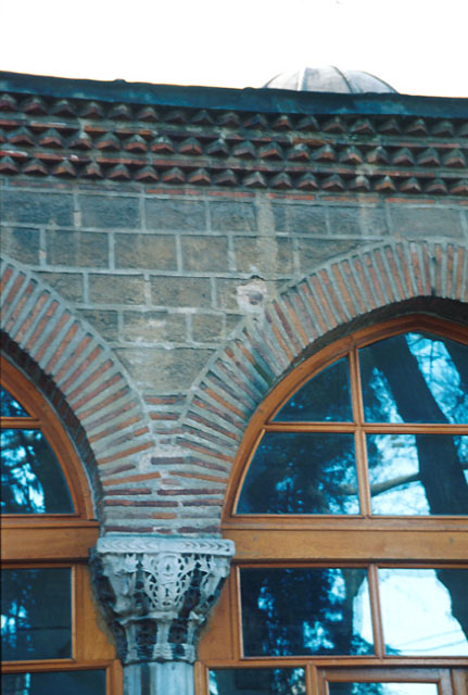 Exterior detail from upper part of portico showing brick arches resting on a Byzantine capital
