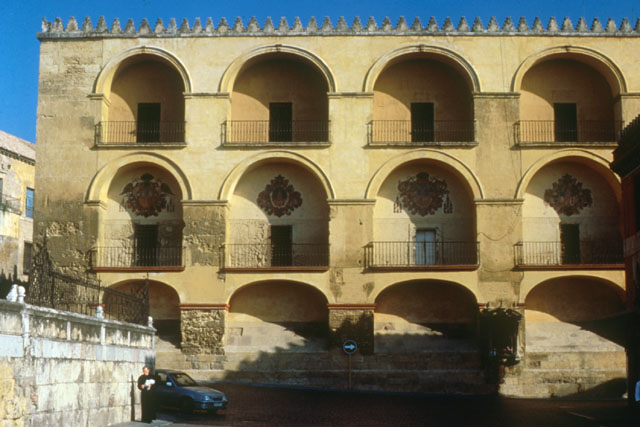 Exterior view showing recessed balconies with iron grate and vaulted ceiling