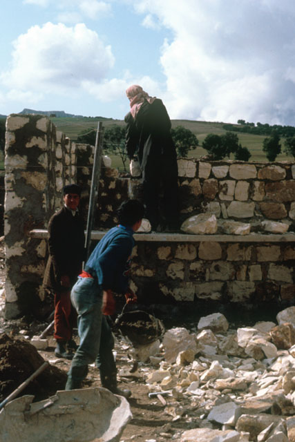 Exterior view showing stone masons at work