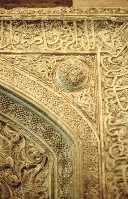 Detail of mihrab  showing floral stucco decoration and inscriptions at upper right corner