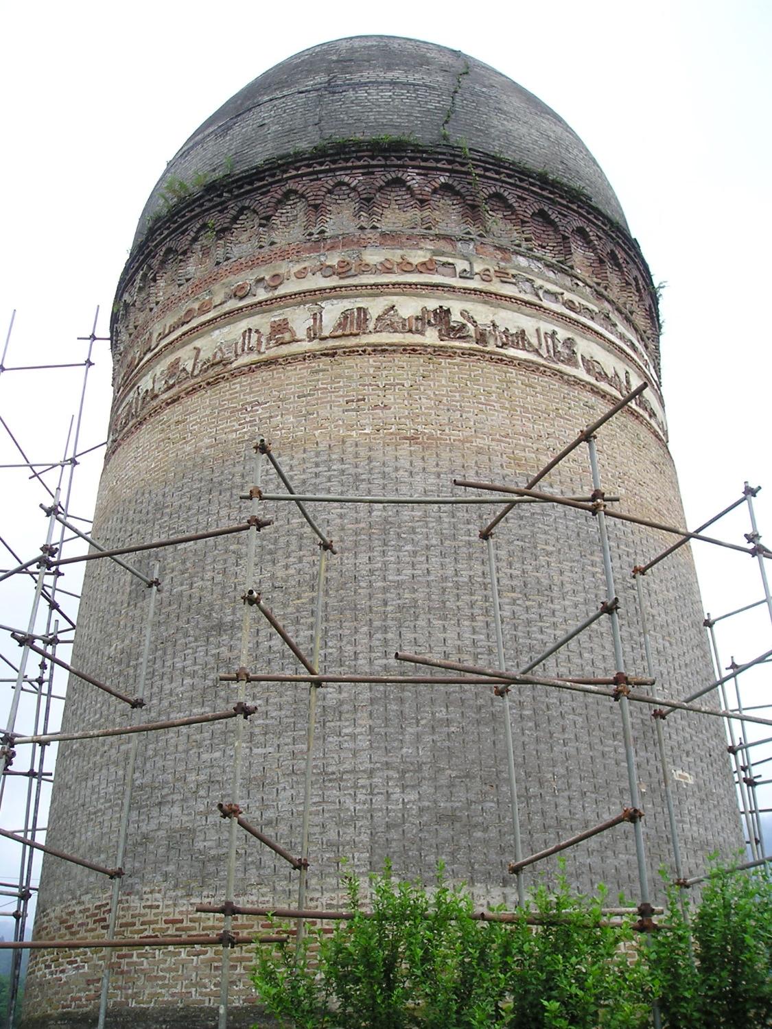 Exterior view showing decorative bands and dome, with scaffolding set up for restoration