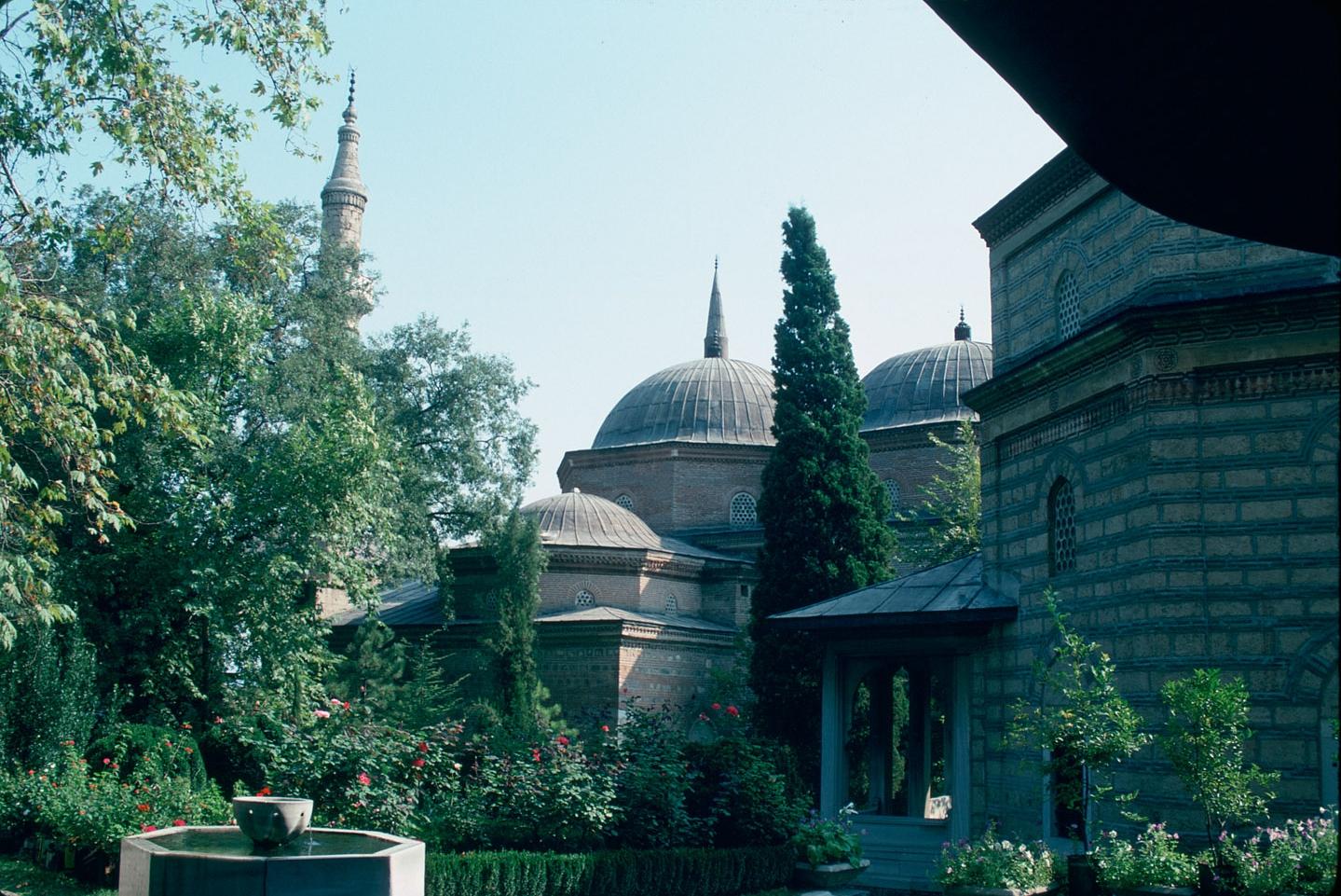 A view, from southwest, of the complex as seen from under the large eaves of the mausoleum of Murat II: the mosque is seen on the left in the distance, with the mausoleum of Mustafa-i Atik on the right