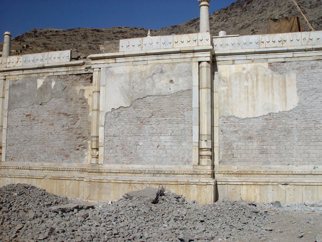 Exterior view from west, showing cement plaster being removed from qibla wall during restoration