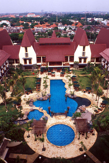 Aerial view showing irregular shaped pool surrounded by guest rooms