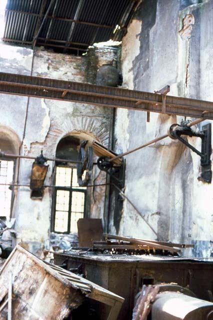 Interior view of mint workshop with rusty machines, before restoration