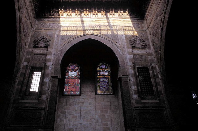 Courtyard view showing archway and polychrome glass windows of northern iwan