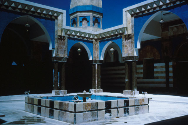 Exterior view showing courtyard with dramatic geometric pattering used in decoration and massing of forms