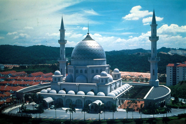 Exterior view showing domes set against terra cotta roofs