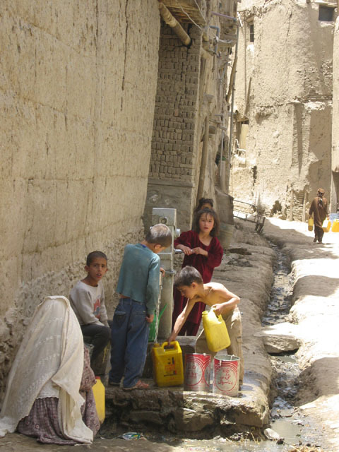 Children pumping water at public well