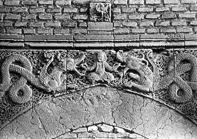 External detail showing the pair of winged dragon-snakes and a human figure sitting cross-legged between them in a way to represent the glorious conqueror