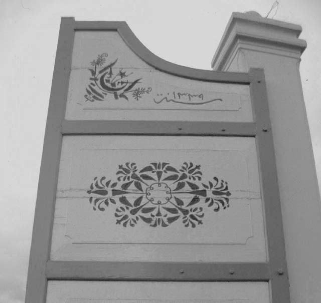 Panels of main entrance gate with geometric and star and crescent motif and date (1339) inscribed in light green paint, prior to repainting
