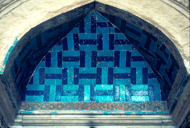Exterior detail from upperside of madrasa portal showing its concave ceiling covered with blue tiles and bordered with carved stone