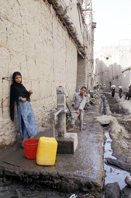 Children pumping water at public well